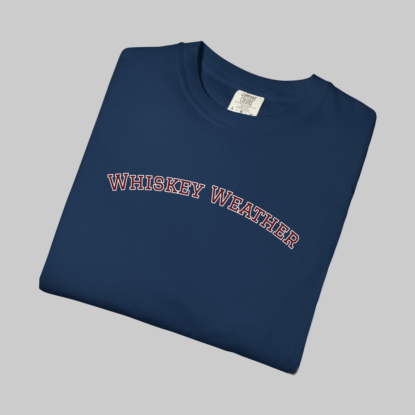 Folded navy blue t-shirt with 'WHISKEY WEATHER' text on a white background