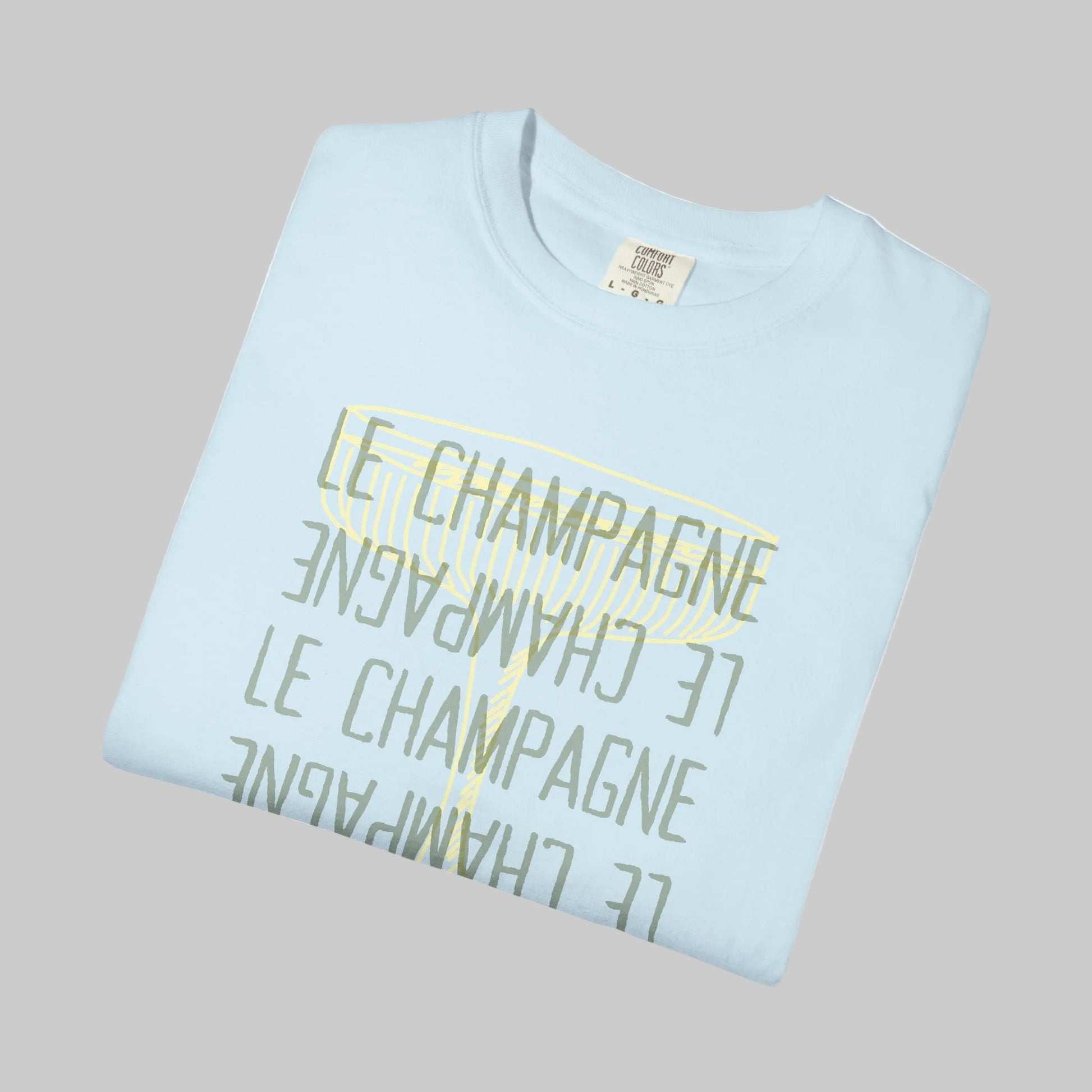 Light blue t-shirt with 'Le Champagne' text printed in gold on a white background