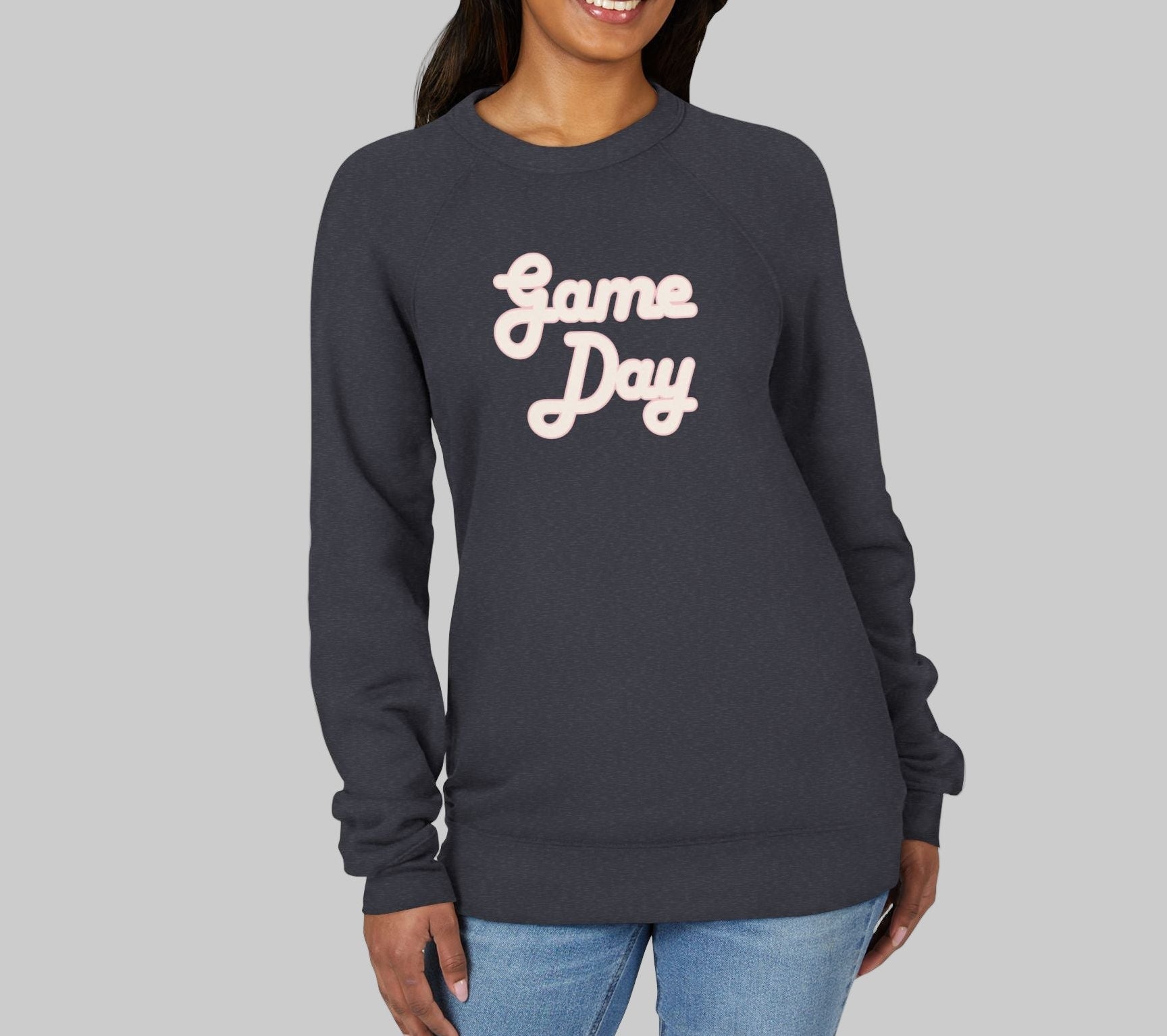Woman wearing a navy sweatshirt with 'Game Day' text on a white background